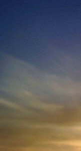 MATTHEW SWARTS A BLURRED SKY WITH SOFT, WISPY CLOUDS AT SUNSET, FEATURING GRADIENTS OF BLUE, PURPLE, AND GOLDEN YELLOW.