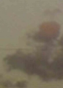 MATTHEW SWARTS A BLURRY IMAGE WITH MUTED COLORS, INCLUDING A REDDISH-ORANGE CIRCULAR SHAPE AND SOME INDISTINCT BROWN AND GREEN AREAS, POSSIBLY SUGGESTING AN ABSTRACT OR OUT-OF-FOCUS LANDSCAPE SCENE.