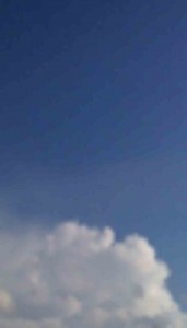 MATTHEW SWARTS A BLURRY IMAGE OF A BLUE SKY WITH WHITE, FLUFFY CLOUDS AT THE BOTTOM.