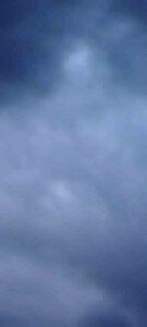 MATTHEW SWARTS BLURRY IMAGE OF A CLOUDY SKY WITH VARIOUS SHADES OF GRAY AND BLUE, CREATING A SOFT, MUTED, AND ABSTRACT APPEARANCE.