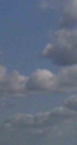 MATTHEW SWARTS BLURRY IMAGE OF A BLUE SKY WITH SEVERAL FLUFFY, WHITE AND GRAY CLOUDS SCATTERED ACROSS IT.
