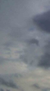 MATTHEW SWARTS A BLURRY IMAGE OF A CLOUDY SKY, FEATURING VARIOUS SHADES OF GRAY AND BLUE WITH PATCHES OF LIGHT AND DARK CLOUDS.