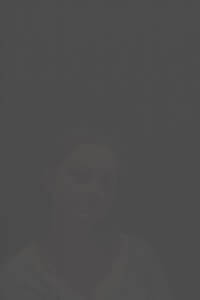 MATTHEW SWARTS A DIMLY LIT, HEAVILY PIXELATED IMAGE SHOWS THE FACE OF A WOMAN WITH SHORT HAIR AND A NEUTRAL EXPRESSION.