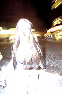 MATTHEW SWARTS A PERSON STANDS ON AN OSLO CITY STREET AT NIGHT, HEAVILY OVEREXPOSED BY A CAMERA FLASH, MAKING THEIR FACE AND UPPER BODY APPEAR BRIGHT WHITE AND UNRECOGNIZABLE. CITY LIGHTS AND BLURRED MOTION IN NORWAY FILL THE BACKGROUND.