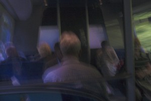 MATTHEW SWARTS BLURRY IMAGE OF SEVERAL PEOPLE SEATED INSIDE A VEHICLE, POSSIBLY A BUS OR TRAIN, WITH LIGHT STREAMING THROUGH THE WINDOWS. THE DREAMLIKE, INDISTINCT EFFECT EVOKES TRAVELS THROUGH DENMARK OR NORWAY IN THE PHOTOGRAPHY OF MATTHEW SWARTS.