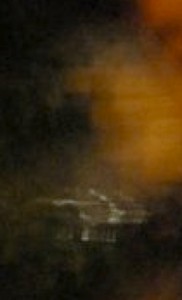 MATTHEW SWARTS A BLURRY, DARK IMAGE WITH AN INDISTINCT WHITE SHAPE IN THE CENTER AND AN ORANGE, CLOUDY AREA IN THE UPPER RIGHT CORNER. THE OBJECTS AND FORMS ARE UNCLEAR DUE TO HEAVY BLUR AND LOW LIGHT.