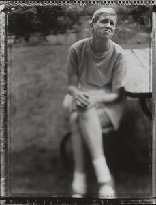 MATTHEW SWARTS BLACK AND WHITE PHOTO BY MATTHEW SWARTS OF A PERSON SITTING ON A BENCH OUTDOORS, HANDS CLASPED AND FACE THOUGHTFUL. THE BLURRY BACKGROUND ADDS A DREAMY, CONTEMPORARY FEEL, AS IF CAPTURING A STILL FROM AN OLD VIDEO.
