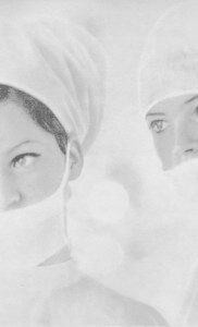 MATTHEW SWARTS TWO WOMEN IN SURGICAL CAPS AND MASKS LOOK AT THE CAMERA.