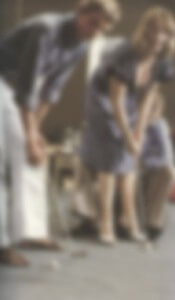 MATTHEW SWARTS A BLURRED IMAGE OF TWO PEOPLE STANDING INDOORS, BENDING FORWARD AND APPEARING TO INTERACT WITH SOMETHING ON THE FLOOR. THEIR FACES AND SURROUNDINGS ARE NOT CLEARLY VISIBLE.