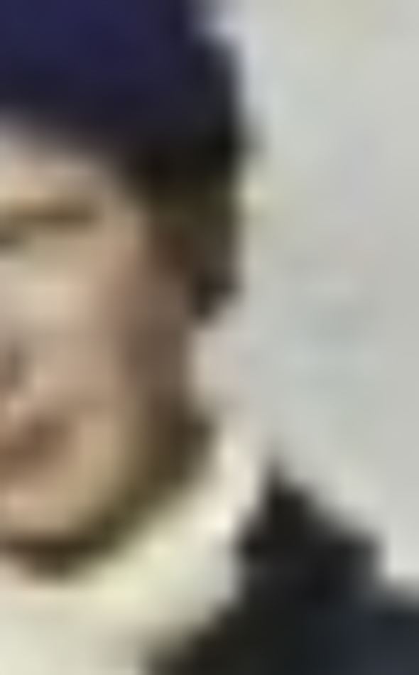MATTHEW SWARTS A blurry close-up image of a person wearing a blue hat and a white scarf or high-collared garment, with indistinct facial features and a neutral background, evokes the expressive style of fine art photography.