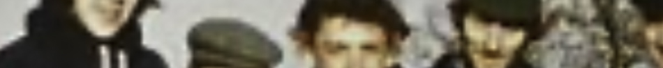 MATTHEW SWARTS A group of five people standing closely together; the image is blurry, making facial features and details difficult to discern, evoking a sense of mystery often found in VISUAL ART by artists like HHEW SWARTS.