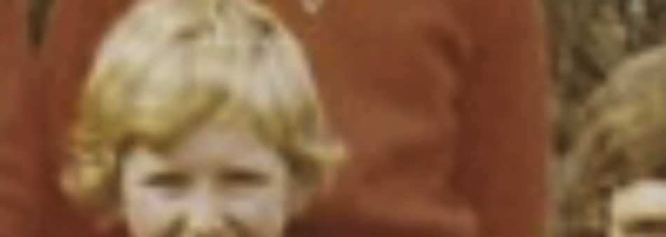 MATTHEW SWARTS A cropped, blurred photo in a contemporary photography style shows two people in red clothing, with one light blond-haired child in the foreground and an adult behind. The indistinct background highlights the photographer’s artistic focus.