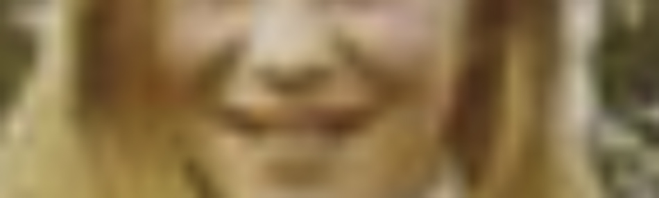 MATTHEW SWARTS A blurred close-up image of a person with long, light brown or blonde hair, smiling outdoors. Captured by photographer Matthew Swarts, this art piece features indistinct facial features and background details due to the blur.