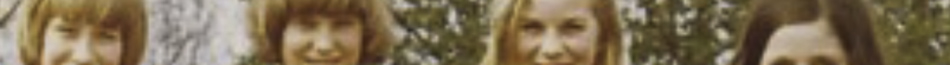 MATTHEW SWARTS A cropped, blurred photo in an artistic style shows the faces of four people with long hair, standing outdoors in front of trees. The image is low resolution, blending art and photography with unclear facial details.