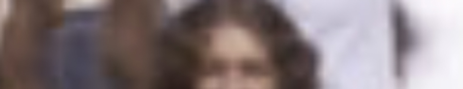 MATTHEW SWARTS A very blurry image with unclear features, possibly showing a person with long brown hair and raised arms—a moment where photography blurs the line between subject and artist. The background is indistinct.