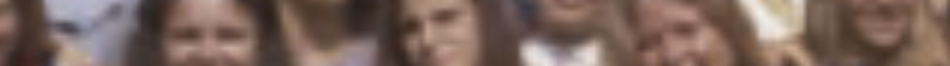 MATTHEW SWARTS A blurred image, likely captured by a contemporary photographer, shows several people standing close together. Their faces are indistinct and colors blend, giving the group an abstract, artful quality as they appear to face the camera.