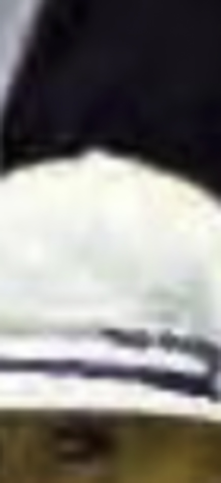 MATTHEW SWARTS A close-up of a white hat with a dark horizontal stripe, set against a dark background. The image, in the style of contemporary photography by Matthew Swarts, is blurry and only part of the hat is visible.