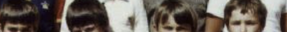 MATTHEW SWARTS A cropped, blurry photo by contemporary artist Matthew Swarts, showing the heads and upper faces of several young children standing close together. The background and details are not clearly visible.