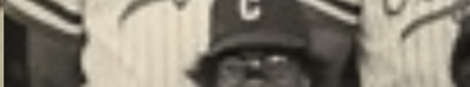 MATTHEW SWARTS A cropped, blurry black-and-white PHOTOGRAPHY shot of a person wearing a baseball helmet with the letter C, partially visible among others in striped jerseys—capturing sport as fleeting ART.