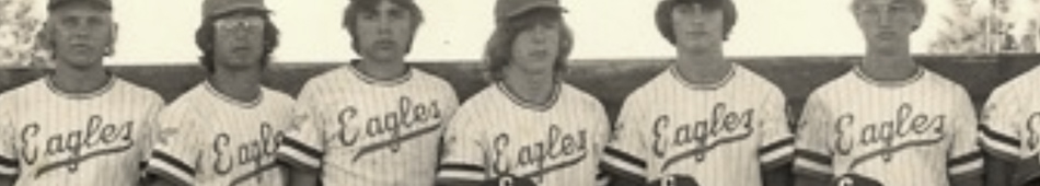 MATTHEW SWARTS A vintage black-and-white photograph by Matthew Swarts captures a baseball team standing in a row, all wearing striped Eagles jerseys and caps, with trees visible in the background—a timeless moment in photography.