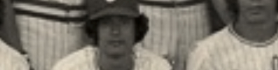 MATTHEW SWARTS A sepia-toned, blurry photo in the style of fine art photography shows a baseball player in uniform and cap seated before teammates. The team’s pinstriped jerseys appear behind him, reminiscent of Matthew Swarts’ visual art approach.