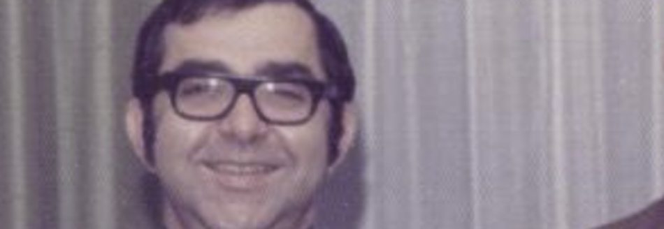 MATTHEW SWARTS A smiling middle-aged man with dark hair, wearing black glasses and a suit, stands in front of beige curtains, perfectly capturing the elegance of fine art photography.