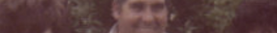 MATTHEW SWARTS A blurry, reddish-tinted photograph in the style of fine art photography shows a smiling person in the center, with portions of two others on either side; trees or foliage appear in the background.