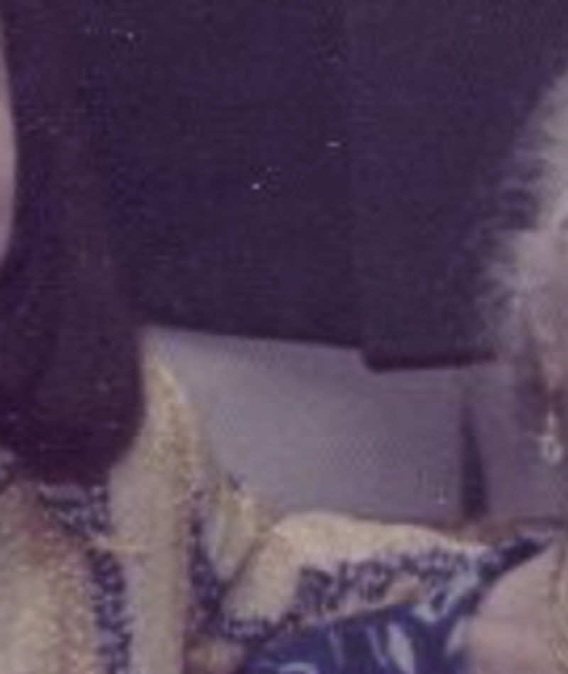MATTHEW SWARTS A cropped, blurry photo in the style of FINE ART PHOTOGRAPHY shows part of two people sitting closely—one in a yellow patterned top, the other with white hair and a blue patterned garment. Faces are mostly out of frame, evoking MATTHEW SWARTS' ART.