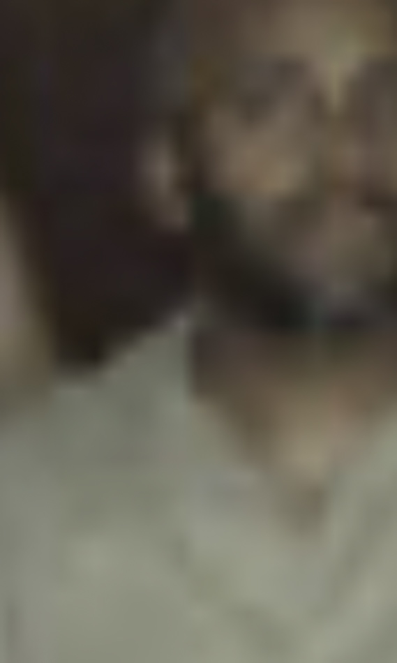 MATTHEW SWARTS A blurry, close-up image of a person with dark skin wearing a light-colored shirt. The indistinct facial features and background evoke the abstract qualities often explored in contemporary art photography.