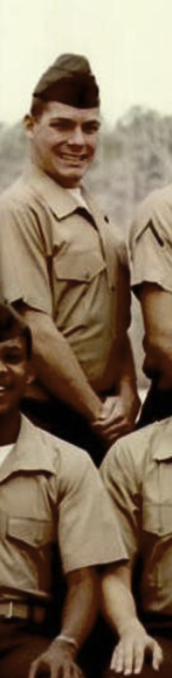 MATTHEW SWARTS A young man in a tan military uniform and cap stands outside, smiling, with his hands clasped in front of him. The scene captures a candid moment reminiscent of contemporary art, with other people in similar uniforms partially visible beside him.