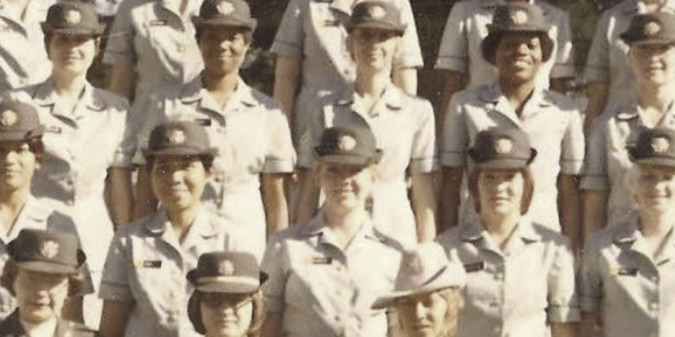 MATTHEW SWARTS A group of women in uniform, standing and posing for a formal group photo outdoors. This scene, with light-colored shirts and dark hats with badges, evokes the style of fine art photography within contemporary visual art.