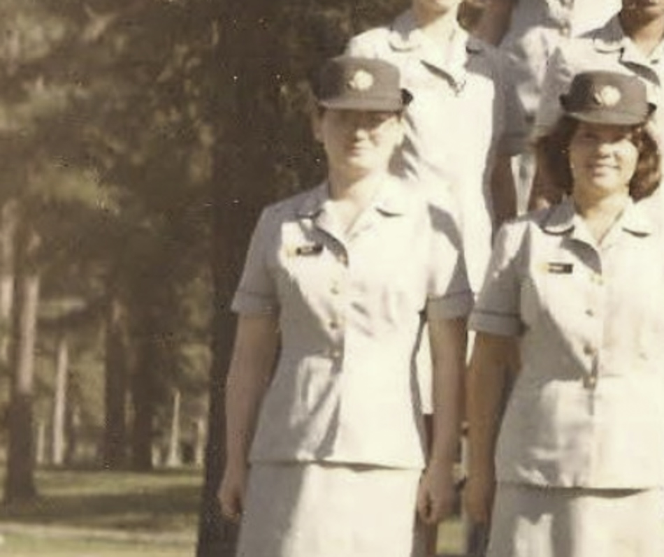 MATTHEW SWARTS Two women in light-colored military uniforms and hats stand outdoors in a line, with others partially visible behind them. Sunlight filters through the trees in this evocative image by ARTIST MATTHEW SWARTS.