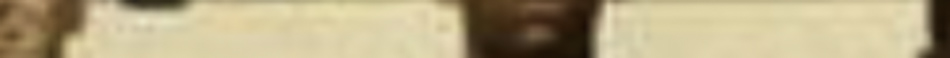 MATTHEW SWARTS A blurry close-up in the style of fine art photography, this image captures two cream-colored, rectangular surfaces with brown vertical borders between them. The indistinct details lend an abstract, visual art quality to the scene.