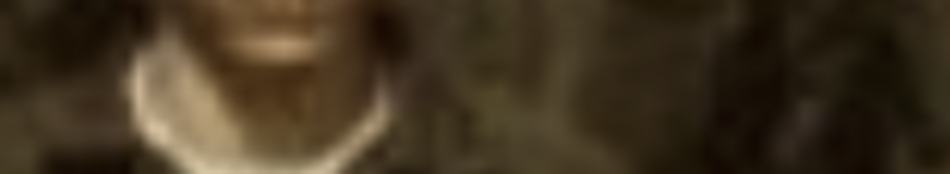 MATTHEW SWARTS A blurry, close-up image in the style of contemporary art shows part of a person wearing a brown jacket over a white shirt, with the background appearing indistinct and out of focus.