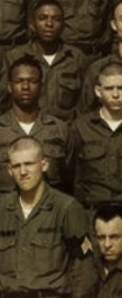 MATTHEW SWARTS Four men in military uniforms stand in rows for a group photo. Their serious expressions and green jackets evoke the disciplined style of ART, with one sergeant insignia on the lower right. The background is out of focus, like a work by ARTIST MATTHEW SWARTS.