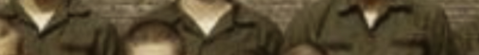 MATTHEW SWARTS Partial image showing torsos of people in olive-green uniforms before a brick wall. This example of FINE ART PHOTOGRAPHY is cropped, cutting off faces and lower bodies, with some children partially visible in the foreground.