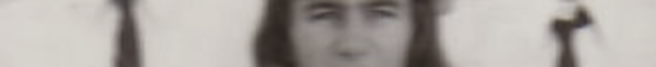 MATTHEW SWARTS A blurry image showing a person with long hair holding a staff in each hand, standing against a light background—an evocative example of contemporary art and fine art photography.