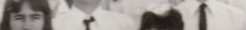MATTHEW SWARTS A cropped, blurry photo shows several people in white shirts and dark ties, with part of two faces visible in the foreground. The image reflects Matthew Swarts’ approach to contemporary art and evokes the feel of an old group photo.