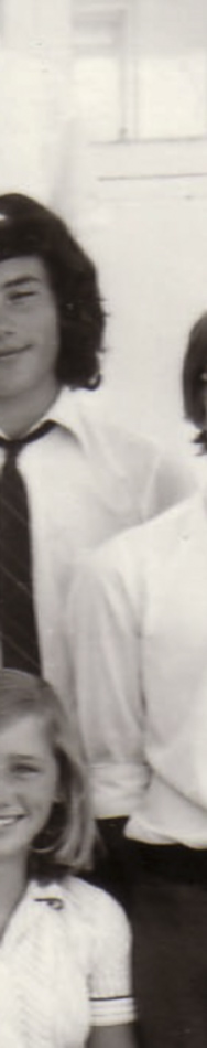MATTHEW SWARTS A black-and-white photo in the style of fine art photography shows three people in white shirts; one person with long dark hair and a tie, another with glasses, and part of a woman smiling at the bottom. The image is cropped vertically.