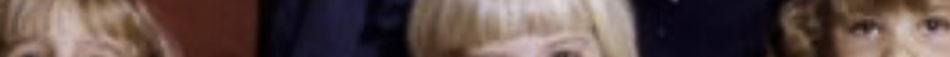 MATTHEW SWARTS A blurry, close-up image of three people with light hair standing side by side in front of a dark and red background. Created by Matthew Swarts, this piece blurs details through motion, highlighting the expressive potential of visual art.