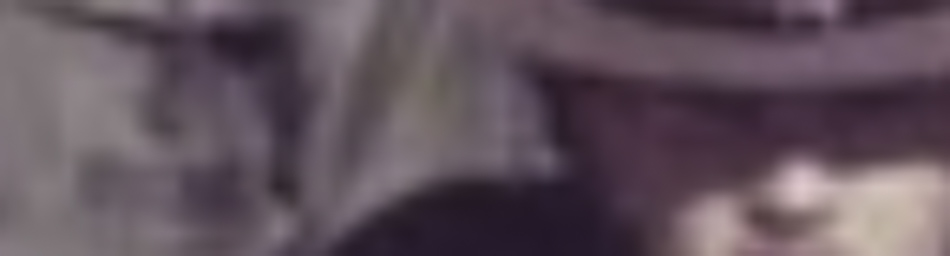 MATTHEW SWARTS A blurred image in the style of fine art photography, showing a person wearing a hat. The details of the face and clothing are indistinct due to the blurriness, evoking a sense of contemporary art.