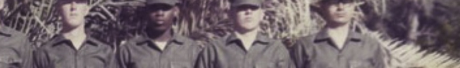 MATTHEW SWARTS A vintage photo shows four people standing outdoors in military uniforms and caps, with trees or dense foliage in the background. The faded, sepia tone gives the image a timeless quality often admired in visual art.