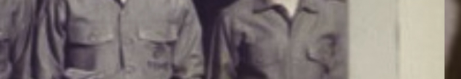 MATTHEW SWARTS Two people stand side by side, both wearing long-sleeved uniforms with buttoned pockets on the chest. This cropped image focuses on their torsos and arms, highlighting the composition’s subtle artistry and FINE ART PHOTOGRAPHY aesthetic.